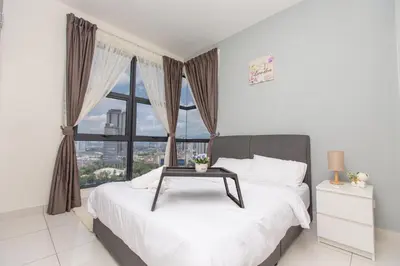 a bedroom with a bed with a table on it at Arte Mont Kiara by MY TRIP & MY STAY in Kuala Lumpur