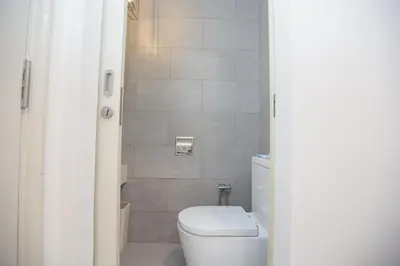 a bathroom with a white toilet and a shower at Arte Mont Kiara by MY TRIP & MY STAY in Kuala Lumpur