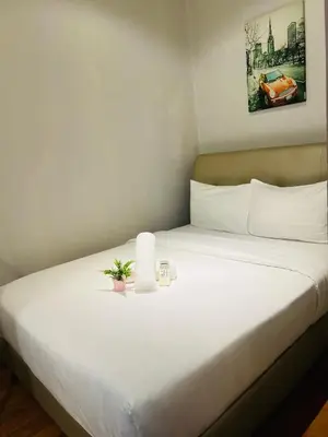 a white bed with a plant on top of it at Soho Suites KLCC by Comfort Suites Kuala Lumpur in Kuala Lumpur