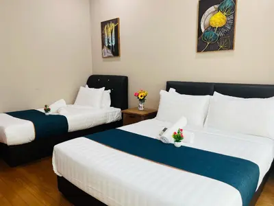 two beds in a hotel room with white and blue sheets at Soho Suites KLCC by Comfort Suites Kuala Lumpur in Kuala Lumpur