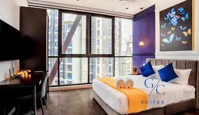 a bedroom with a bed with a desk and a large window at Scarletz KLCC luxury suites by GC-Suites in Kuala Lumpur