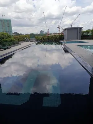 a pool with a reflection of the sky in the water at KL2-4pax studio nr KTM&Midvalley in Kuala Lumpur