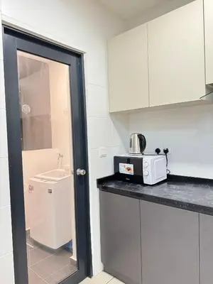 a kitchen with white cabinets and a microwave on a counter at REIZZ RESIDENCE BY BERJAYA in Kuala Lumpur