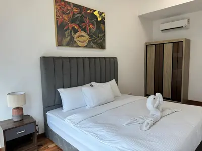 a bed with a swan towel laying on it at REIZZ RESIDENCE BY BERJAYA in Kuala Lumpur