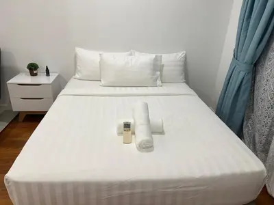 a white bed with two pillows at Summer Suites KLCC By Victorians in Kuala Lumpur