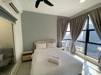 a bedroom with a large bed and large windows at VALENTINA SUITES @ ARTE MONT KIARA in Kuala Lumpur