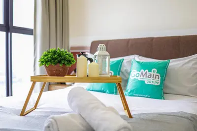 a bed with a wooden table with a bottle of soap and a plant at [4 Pax] Trion KL // Near Pavillion KL KLCC TRX in Kuala Lumpur