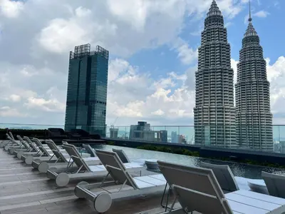 a row of lounge chairs on a roof with buildings at Star at KLCC By EAE in Kuala Lumpur