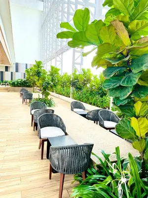 a row of tables and chairs in a building with plants at Voyage Bedroom, The Luxe Colony in Kuala Lumpur