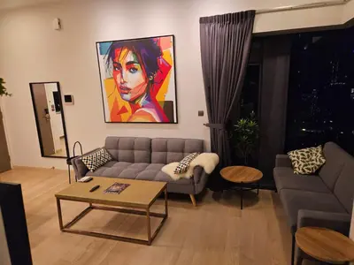 a living room with a couch and a painting on the wall at Star Residence 2br Unit Floor 46 in Kuala Lumpur
