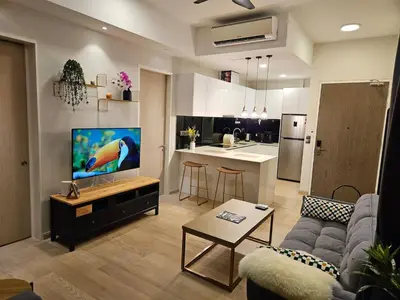 a living room with a couch and a tv and a kitchen at Star Residence 2br Unit Floor 46 in Kuala Lumpur
