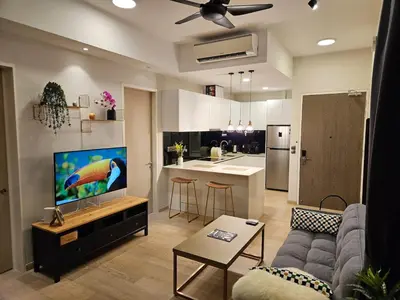 a living room with a couch and a kitchen at Star Residence 2br Unit Floor 46 in Kuala Lumpur
