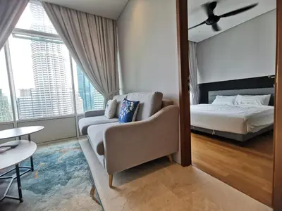 a bedroom with a bed and a couch and a chair at Sky Suites KLCC 3min walk to Twin Tower in Kuala Lumpur