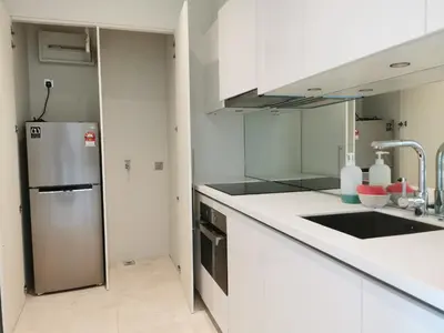 a kitchen with white counters and a stainless steel refrigerator at Sky Suites KLCC 3min walk to Twin Tower in Kuala Lumpur