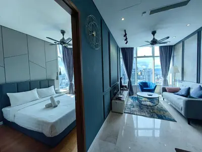 a bedroom with a bed and a living room with a couch at Sky Suites KLCC 3min walk to Twin Tower in Kuala Lumpur