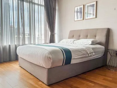 a bed in a bedroom with a large window at Vortex KLCC by apartx in Kuala Lumpur