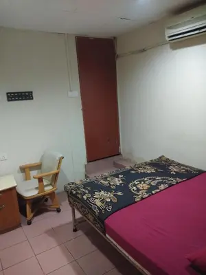 a bedroom with a bed and a desk and a chair at KL CITY LODGE in Kuala Lumpur