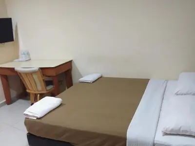 a hotel room with a bed and a desk and a desk at KL CITY LODGE in Kuala Lumpur