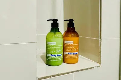 two green and orange bottles sitting on a shelf in a bathroom at Continew by Xuan and Partner near KLCC and Bukit Bintang in Kuala Lumpur