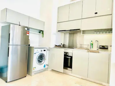 a kitchen with white cabinets and a washer and dryer at Smart Home at Lucentia Residence BBCC Lalaport in Kuala Lumpur