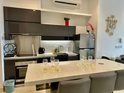 a kitchen with a table with wine glasses on it at Smart Home at Lucentia Residence BBCC Lalaport in Kuala Lumpur