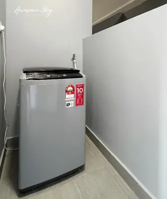 a small refrigerator sitting in a room next to a wall at Trion @ KL By The Relaxstay in Kuala Lumpur