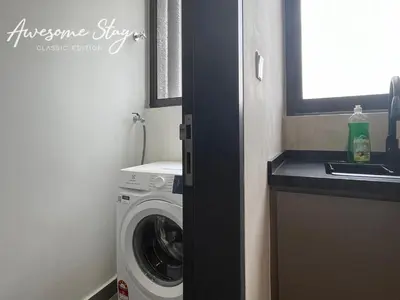 a small bathroom with a washing machine and a sink at Sunway Velocity Two By Awesomestay in Kuala Lumpur
