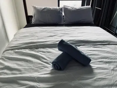 a blue towel laying on a bed at Neu suites advance HomeStay klcc in Kuala Lumpur