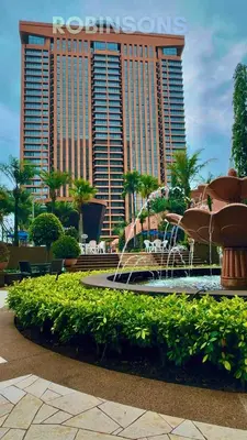 a fountain in a park with a large building at The Suites at Times Square KL by Robinsons in Kuala Lumpur