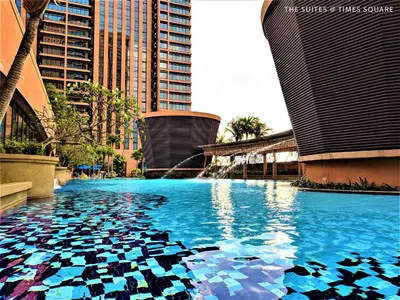 a pool with blue water in a city with tall buildings at The Suites at Times Square KL by Robinsons in Kuala Lumpur