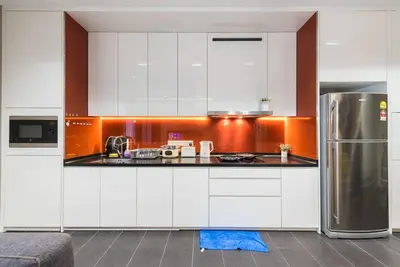 a kitchen with white cabinets and a stainless steel refrigerator at Arcoris Mont Kiara 12# Deluxe 2 Bedroom # Coner with Balcony #1-4Pax in Kuala Lumpur