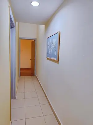 a hallway with a painting on the wall and a tile floor at Fahrenheit88 2minsPavilionKL TRX by Abby Stay in Kuala Lumpur