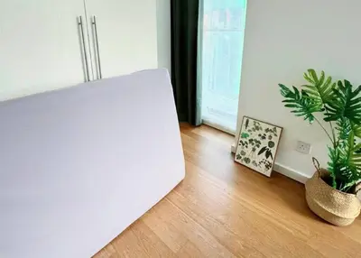 a white laptop sitting on a wooden floor with plants at Bintang Fairlane Residence, KLCC & City Skyline View -2B1R in Kuala Lumpur