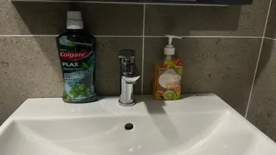 a bathroom sink with a bottle of soap and a bottle of toothpaste at Cozy Studio Kuala Lumpur by LH in Kuala Lumpur