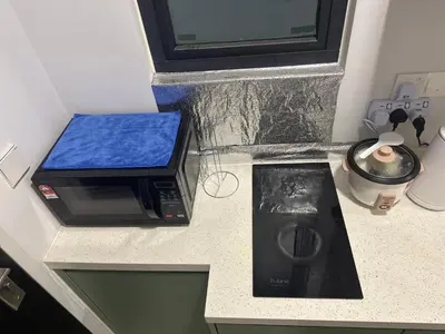 a kitchen counter with a microwave and a washing machine at Cozy Studio Kuala Lumpur by LH in Kuala Lumpur