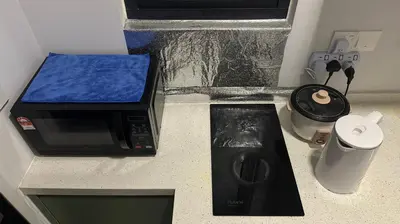 a kitchen counter with a microwave and a coffee maker at Cozy Studio Kuala Lumpur by LH in Kuala Lumpur