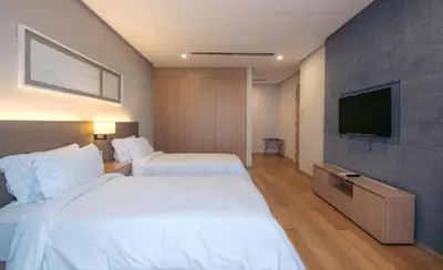a hotel room with two beds and a flat screen tv at Sfera Residence Kuala Lumpur City Centre in Kuala Lumpur