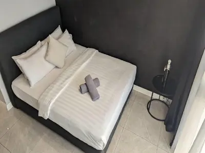 a bed with a purple cross on top of it at Axon Residence Kuala Lumpur Pavilion in Kuala Lumpur