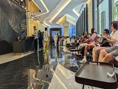 a group of people sitting in chairs in a shopping mall at Axon Residence Kuala Lumpur Pavilion in Kuala Lumpur