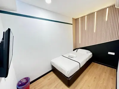 a small room with a bed and a flat screen tv at Seeds Hotel Setia Wangsa in Kuala Lumpur