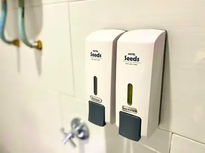 two white soap dispensers on a bathroom wall at Seeds Hotel Setia Wangsa in Kuala Lumpur
