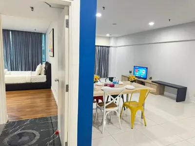 a living room and a dining room with a table at Summer Suites KLCC by Luna KL in Kuala Lumpur