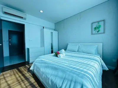 a bedroom with a large bed with a stuffed animal on it at Summer Suites KLCC by Luna KL in Kuala Lumpur