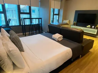 a bedroom with a large bed and a television at Ceylonz Suites By MyStay in Kuala Lumpur