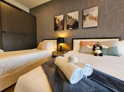 a bedroom with two beds and a teddy bear sitting on the bed at Stylish Ceylonz Suite near Bukit Bintang 4pax in Kuala Lumpur