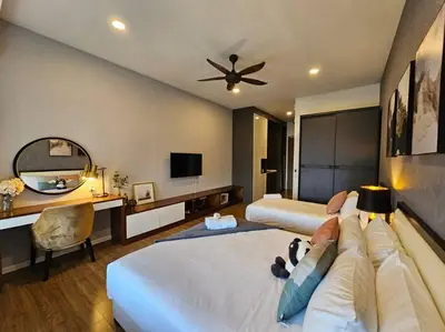 a bedroom with two beds and a desk and a television at Stylish Ceylonz Suite near Bukit Bintang 4pax in Kuala Lumpur