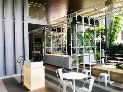 a restaurant with white tables and chairs and plants at Stylish Ceylonz Suite near Bukit Bintang 4pax in Kuala Lumpur