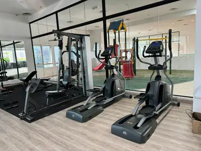 a gym with several treadmills and elliptical machines at Cozy home in city center with free parking -1B in Kuala Lumpur