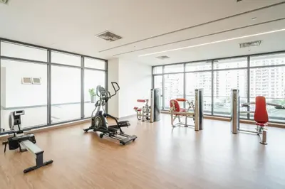 a gym with cardio equipment in a large room with windows at Sentul Homestay 3 Bedroom in Kuala Lumpur
