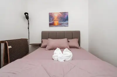 a bed with two white shoes sitting on it at Sentul Homestay 3 Bedroom in Kuala Lumpur